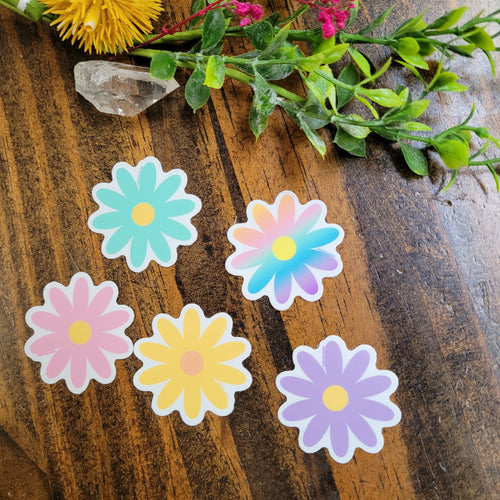 image of 5 mini muliti-colored daisy stickers on a wooden table