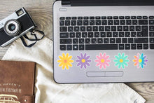 Load image into Gallery viewer, image of 5 multicolored vinyl daisies stuck to a laptop